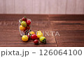 A woman's hand picking up a colorful cherry tomato 126064100