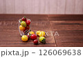 A woman's hand picking up a colorful cherry tomato 126069638