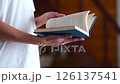 A woman in a white T-shirt flips through and reads a close-up blue book. High quality FullHD footage 126137541