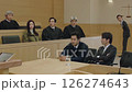 Serious courtroom scene unfolds, lawyers present arguments formal trial. Judge presides, ensuring fair process through important legal trial. Solemn trial reflects pursuit truth justice legal system. 126274643