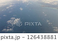 airplane flying above clouds and offshore wind turbines 126438881
