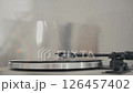 Close-up of vinyl record player needle on spinning turntable surface.  126457402