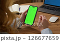 Woman sit use digital tech cell phone open green screen mock up. Hand scroll phone web site swipe unlock. Girl hold mobile closeup. Turn on chroma key page Cozy home background. Online app copy space 126677659