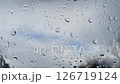 It's raining outside. Raindrops crawl on the glass against the sky 126719124