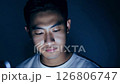 Dramatic dolly zoom video of a young man working late at night, illuminated by his laptop screen 126806747