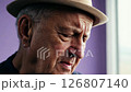 Close-up video of an elderly man with a hat, expressing sadness with natural window light and static camera movement. 126807140