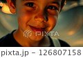 Close-up video of a teenage boy with a skateboard, expressing curiosity in a blurred skate park background, warm intimate lighting, static camera movement. 126807158