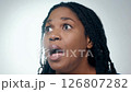 Close-up video of a surprised middle-aged Black woman with locs against a white background, soft diffused light, static video 126807282