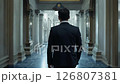 A dapper 42-year-old asian male lawyer walks confidently down a formal hallway as the camera slowly zooms out 126807381