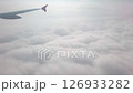 Cloud in sky. Plane flight through dense fluffy puffs of white cloud at sky. Flying in soft clouds, looking from airplane window 126933282