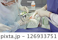 Two dental professionals perform a procedure on a patient in a clinical environment, focused and attentive to details 126933751
