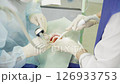 Two dental professionals perform a procedure on a patient in a clinical environment, focused and attentive to details 126933753