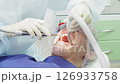 Dental professional performs cleaning procedure on a patient to remove plaque, ensuring dental health and teeth whiteness 126933758