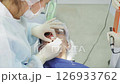 Medical professional applies ultraviolet light to cure a dental filling, ensuring proper adhesion and longevity for the patient in a clinical setting 126933762