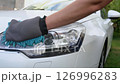 Washing a car headlight with a microfiber glove. Car care and cleaning. Auto detailing and maintenance. Paint protection. Vehicle care. 126996283