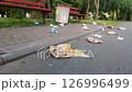 Neglected park with trash. Leftover fast food. Environmental pollution from waste. Littered pedestrian zone. Carelessness and human pollution concept.  126996499
