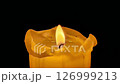 Single big yellow candle flame lights and extinguish, isolated on a black background. Slow motion, central framing close up. 126999213
