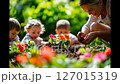 A mother and children planting colorful flowers together in a sunlit garden, enjoying nature and bonding through gardening 127015319