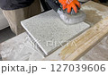 Man using a grinder to polish a piece of decorative concrete 127039606