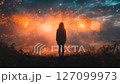 Woman standing in a field looking at fireworks 127099973