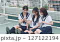 A high school girl looking at a smartphone on the rooftop 127122194