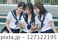 A high school girl looking at a smartphone on the rooftop 127122195