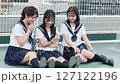 A high school girl looking at a smartphone on the rooftop 127122196