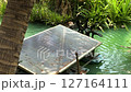 Close-up of a solar cell paddle wheel aerator running in a small canal of a farm. Space for text and landscape footage of a Solar cell paddle wheel aerator in a small canal. Real-time footage. 127164111