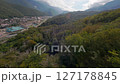 Drone dive above green forest to mountain resort 127178845