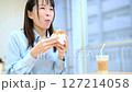 リビングで美味しそうにハンバーガーを食べる女性 127214058