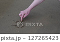 Creative Hand Drawing Heart and Gender Symbols on Smooth Sandy Beach Surface in Natural Outdoor Setting 127265423