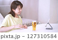 Young woman enjoying an online drinking party 127310584