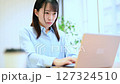 ノートパソコンで仕事する若い女性　リビングでテレワーク 127324510