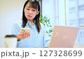 テレワークをする若い女性　スマホを見て指示を受け取る　連絡相談 127328699