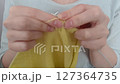 Hands of a woman knitting video. Hands close-up knitting yellow yarn with needles 127364735