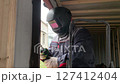 A builder uses a welding machine to make a window frame. 127412404