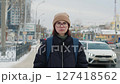 Young woman standing on a city sidewalk in winter 127418562