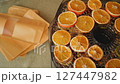 Chef carefully placing dried orange slices from a food dehydrator into paper bags 127447982