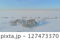 Aerial view of cold winter landscape arctic field, trees covered with frost snow, ice river and sun rays over horizon. Extreme low temperature weather. 127473370