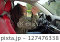 Beautiful African American female driver driving car in city traffic, getting into motor vehicle collision during road trip, showing confusion and shock after car crash. 127476338
