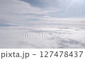Clouds in sky. Airplane flight over white cloud and sun beams at high up sky. Fly in clear softness clouds at sunny light day, looking from plane window 127478437