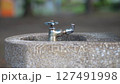 公園の水道の蛇口を捻って水を出す 127491998