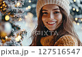 Joyful winter scene with smiling woman by snowy tree and festive lights in magical atmospheric setting, Christmas  127516547