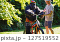 Gorilla gets help from man learning to ride a bike Gorilla gets help from man learning to ride a bike 127519552
