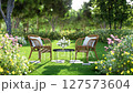 3d animation render of a serene garden patio with two wicker chairs and a small table 127573604