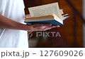 A woman in a white T-shirt flips through and reads a close-up blue book. High quality FullHD footage 127609026