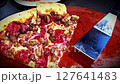 Delicious pizza featuring a combination of cheese and meat lovers toppings, served on a wooden board. The golden cheese stuffed crust and melting cheese emphasize fresh and irresistible flavors, creat 127641483