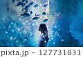 A Japanese woman at the aquarium. Scenery in a blue aquarium. Tropical fish and summer. 127731831
