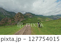 Mountain biker riding across alpine field 127754015