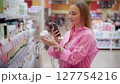 Customer scanning product with smartphone in supermarket 127754216